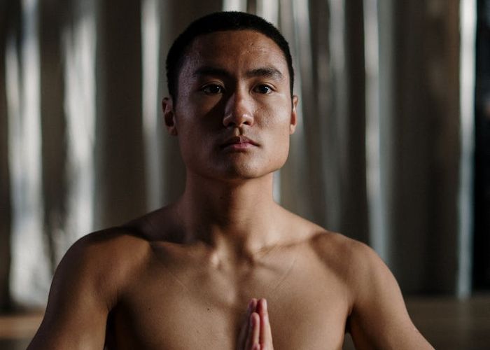 Person practicing yoga in a dark modern studio.